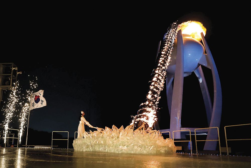 South Korean figure skater Kim Yu-na lights the cauldron with the Olympic Flame during the opening ceremony of the Pyeongchang 2018 Winter Olympic Games at the Pyeongchang Stadium on February 9, 2018. / AFP PHOTO / POOL / David J.PHILIP (Photo credit should read DAVID J.PHILIP/AFP/Getty Images)